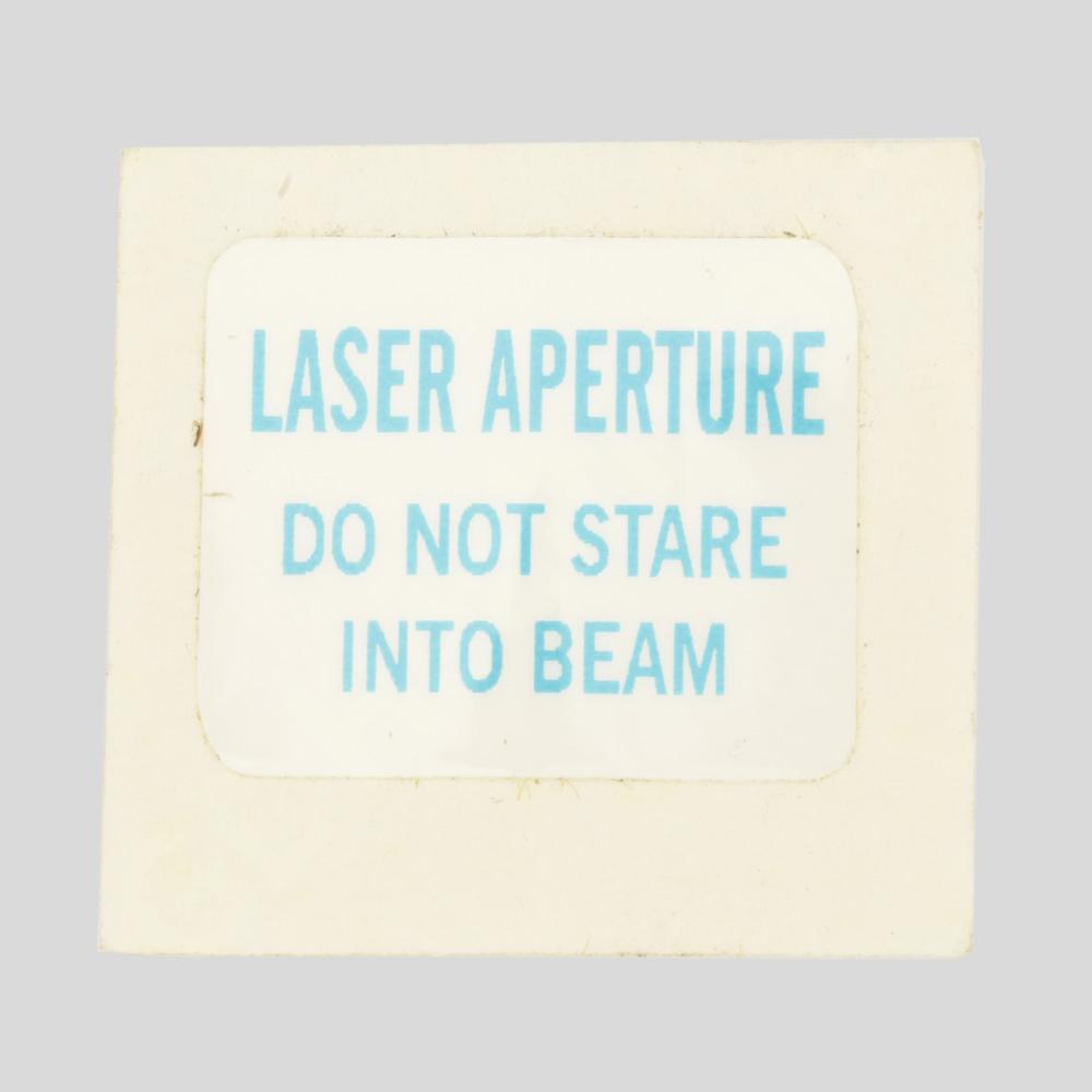 LASER APERTURE, DONT STARE INTO BEAM ADHESIVE BACKED LASER APERTURE, DONT STARE INTO BEAM ADHESIVE BACKED